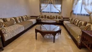 a living room with couches and a coffee table at Prestige Villa in Marrakesh +10 photos