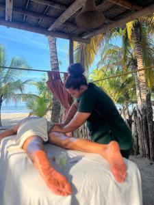 a man shaving his leg on a bed on the beach at Manoush Beach in Buritaca