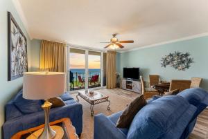 a living room with a blue couch and a television at Goin Coastal Emerald Beach Unit 729 in Panama City Beach