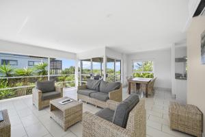 ein Wohnzimmer mit Sofas und einem Tisch in der Unterkunft Beachfront Family Apt - Ocean Views in Diamond Beach