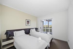zwei Betten in einem Zimmer mit Fenster in der Unterkunft Beachfront Family Apt - Ocean Views in Diamond Beach + 24 Fotos