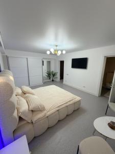 a white living room with a couch and a tv at LVO Studio in Bîrlad +9 photos