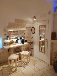 a kitchen with a table and two stools in a room at Dimora Bianca Ostuni in Ostuni