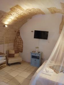 a bedroom with a bed and a tv in a room at Dimora Bianca Ostuni in Ostuni