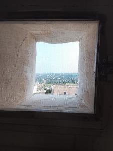 a window in a building with a view of the city at Dimora Bianca Ostuni in Ostuni