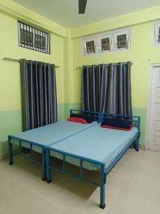 a bedroom with a blue bed in a room at Patkai Backpackers Hostel in Guwahati