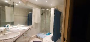 a bathroom with two sinks and a shower and a tub at Colocation Du Grand Large in Décines-Charpieu