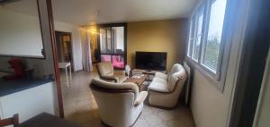 a living room with several chairs and a television at Colocation Du Grand Large in Décines-Charpieu +2 photos