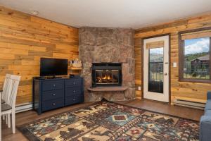 a living room with a fireplace and a tv at 564 Silvercreek Inn in Granby