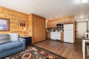 a living room with a blue couch and a kitchen at 564 Silvercreek Inn in Granby