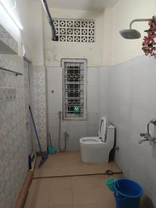 a small bathroom with a toilet and a window at Patkai Backpackers Hostel in Guwahati +7 photos