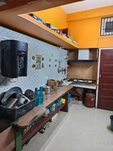 a kitchen with a counter and a tv on the wall at Patkai Backpackers Hostel in Guwahati