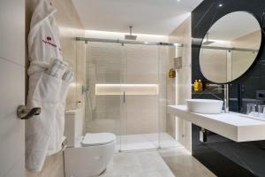 a bathroom with a toilet and a sink and a mirror at Hotel Pasarela in Seville +95 photos