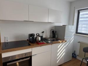 a white kitchen with a sink and a refrigerator at Ferienwohnung LuMa in Rottenacker in Rottenacker