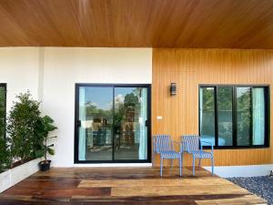 two chairs sitting on a deck in front of a house at Aonang Green Tree in Ao Nang 