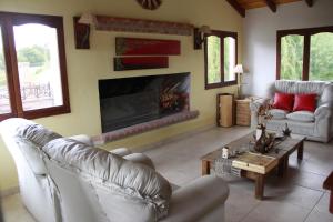 a living room with two chairs and a fireplace at Posada Shemak in Villa General Belgrano