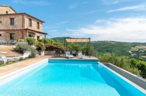 an outdoor swimming pool in front of a house at Villa Badia, large villa in Umbria with private pool in Città di Castello