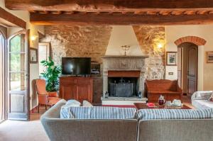 a living room with a couch and a fireplace at Villa Badia, large villa in Umbria with private pool in Città di Castello