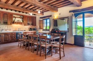 a kitchen with wooden cabinets and a wooden table and chairs at Villa Badia, large villa in Umbria with private pool in Città di Castello