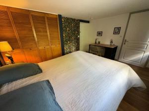 a large white bed in a bedroom with a desk at Le Lavoir de Loches in Loches +4 photos
