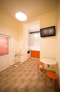 リヴィウにあるApartment on Rappoporta 7a-4のテーブル、椅子2脚、テレビが備わる客室です。