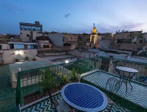 a balcony with a table and a view of a city at Dar El Kendil in Fez