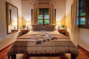 a bedroom with a large bed with a hat on it at Estancia Iberá in Colonia Carlos Pellegrini +117 photos