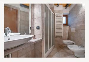 a bathroom with two sinks and a tub and a toilet at La casa dei Pasqui' in Bollone +20 photos