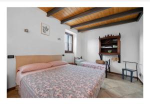 a bedroom with two beds and a table in it at La casa dei Pasqui' in Bollone