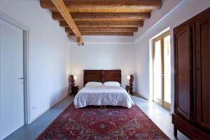 a bedroom with a bed and a red rug at Casa Adami Due in Brussa