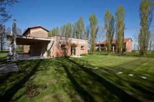 a brick building in the middle of a grass field at Casa Adami Due in Brussa