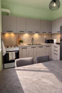 a kitchen with white cabinets and a table with chairs at The Citrus Yard in Politika, 2 bedrooms apartment in Politika