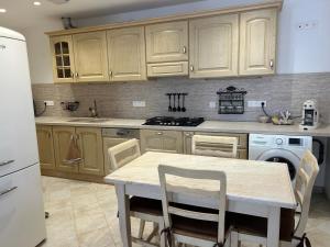 a kitchen with wooden cabinets and a table with chairs at gîte des gorges de Daluis appartement 2 pieces in Daluis