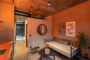 a bedroom with a bed and a table and a mirror at The Quiet Garden in Jacó