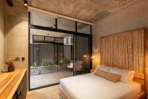 a bedroom with a bed and a large window at The Quiet Garden in Jacó +33 photos