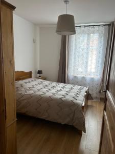 a bedroom with a bed and a large window at gîte des gorges de Daluis appartement 2 pieces in Daluis