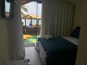 a bedroom with a bed and a view of the ocean at Suíte dos Reis in Angra dos Reis