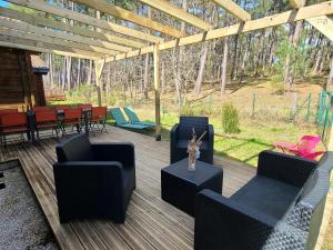 a patio with chairs and a table with a vase on it at Chalet en bois in Bias