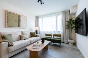 a living room with a couch and a table at Apartamentos Plaza España - Enjoy Sevilla in Seville