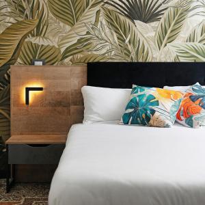 a bedroom with a bed and a wall with leaves at Janua Jungle House in Genoa