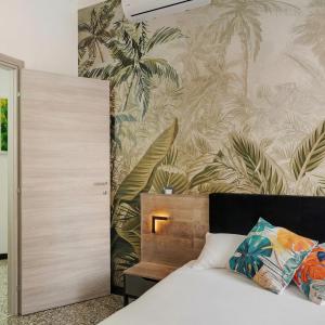 a bedroom with a bed with a tropical wallpaper at Janua Jungle House in Genoa