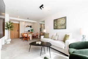 a living room with a white couch and a table at Apartamentos Plaza España - Enjoy Sevilla in Seville