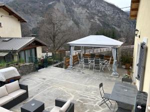 a patio with a white umbrella and tables and chairs at gîte des gorges de Daluis appartement 2 pieces in Daluis