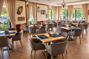 a restaurant with tables and chairs and windows at Sea Vista Hotel in Sveti Vlas
