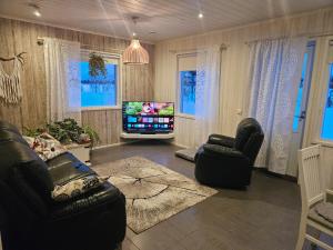 a living room with two chairs and a television at Villa Sevettijärvi in Sevettijärvi