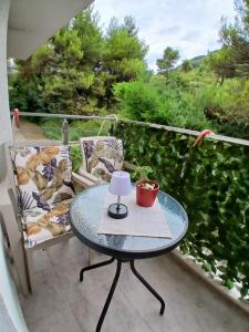 a table on a balcony with a lamp on it at Jednosoban stan Tivat in Tivat