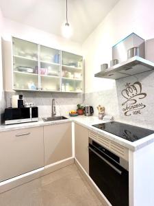 a kitchen with white cabinets and a black stove top oven at Princess Home in Marina di Massa