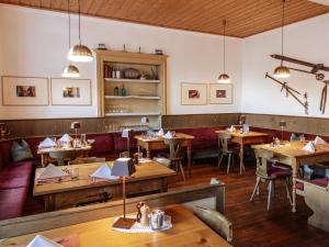 a restaurant with wooden tables and chairs in a room at Berghotel Franzenshöhe in Trafoi +42 photos