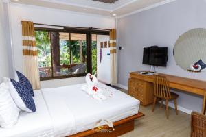 a bedroom with a bed and a desk and a television at Suanya Kohkood Resort and Spa in Ko Kood
