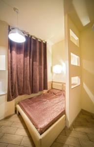 een slaapkamer met een bed en een raam met een gordijn bij Mini Apartment on Rappoporta 7a-3 in Lviv